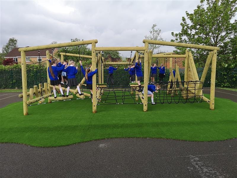 children climb on the timber climbing frame with rope challenges 
