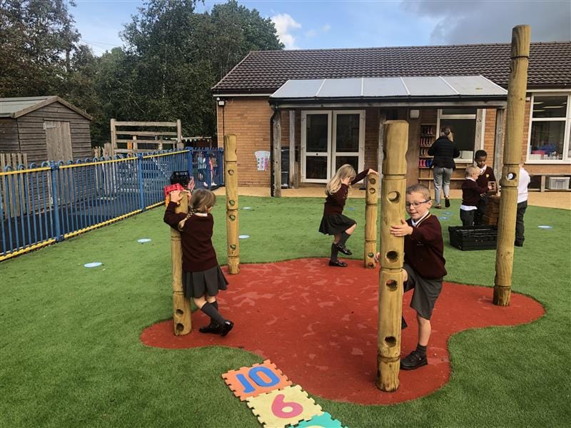 children playing with den making posts on the red safeturf and artifical grass