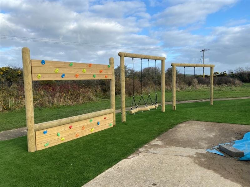 a view of the individual trim trail items including climbing wall, log crossing and drop rope traverse