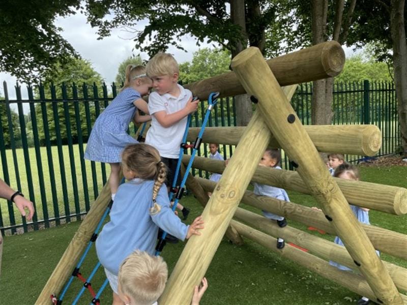 children climb along the timber and net in blue, white and black school uniform