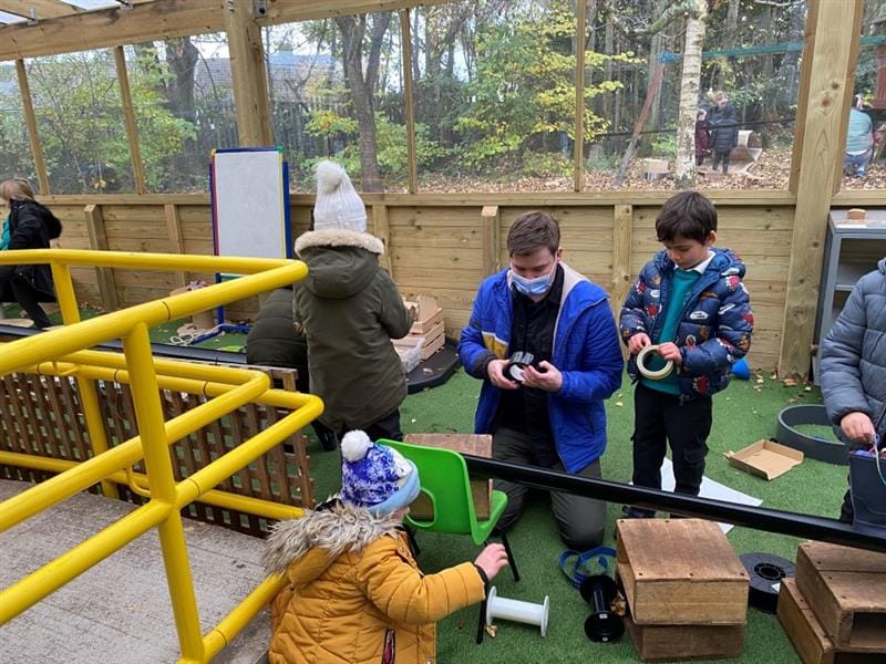 a member of our products team sits and demonstrates product construction with a class of pupils