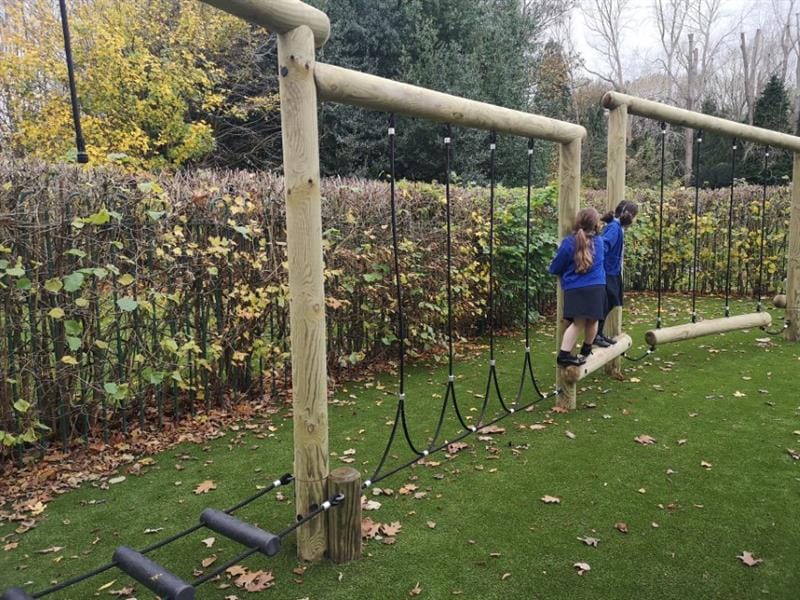 Two children moving across a pentagon play forest trim trail