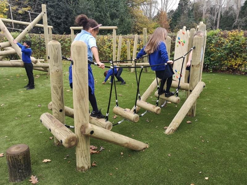 Children balancing on a wobbly bridge on a trim trail
