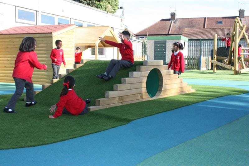 children slide down a climb through tunnel hill