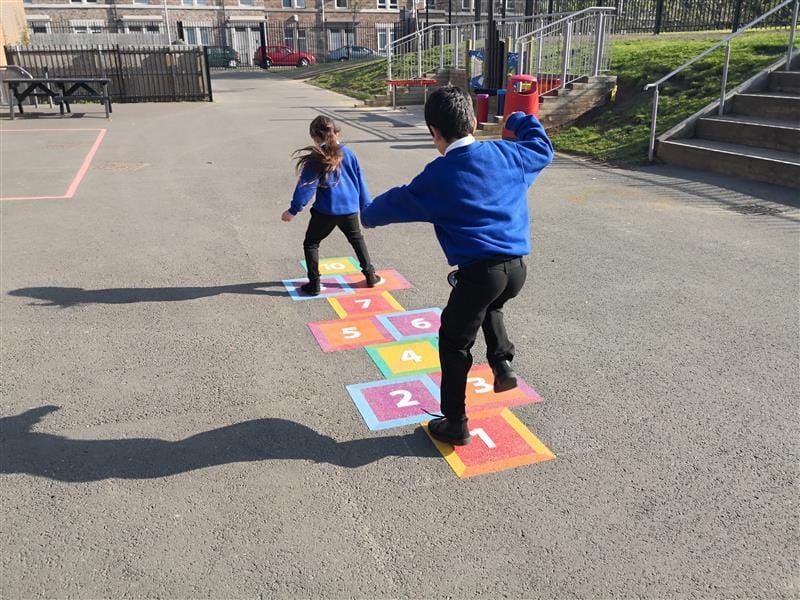 children play on the hopscotch playground marking