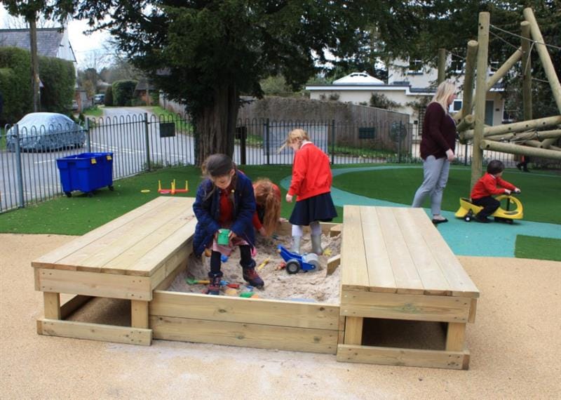 children stand in the sandbox and play with the materials