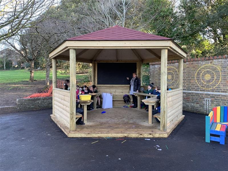 Children participating in a lesson in an outdoor gazebo