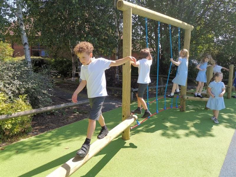 a child crosses the incline balance beam