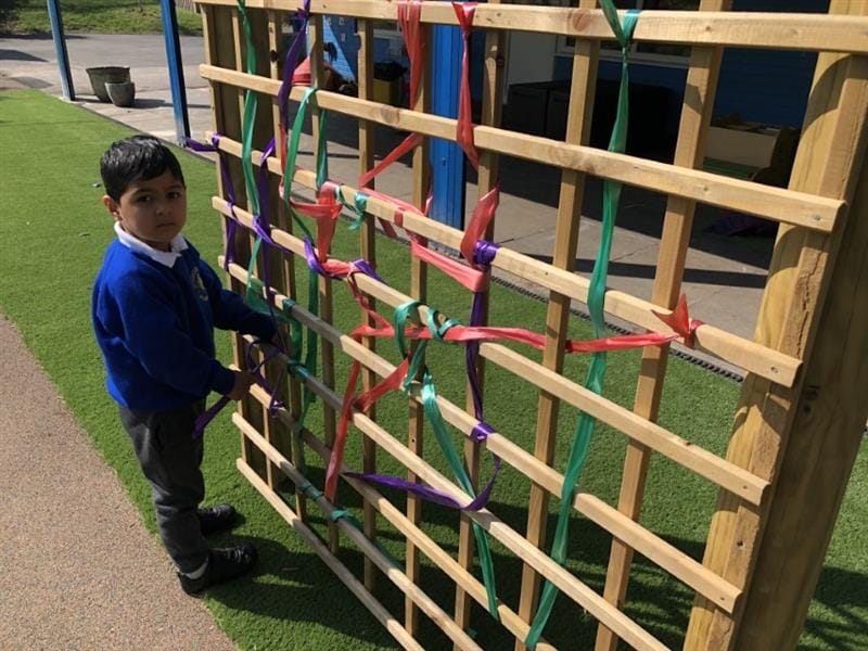 Child weaving on a playground weaving panel
