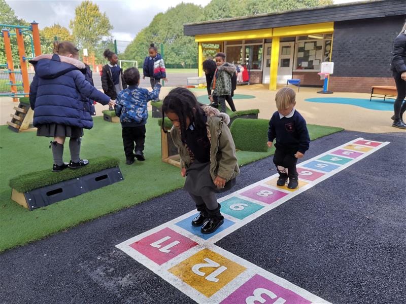 Children playing on number markings on a playground surface