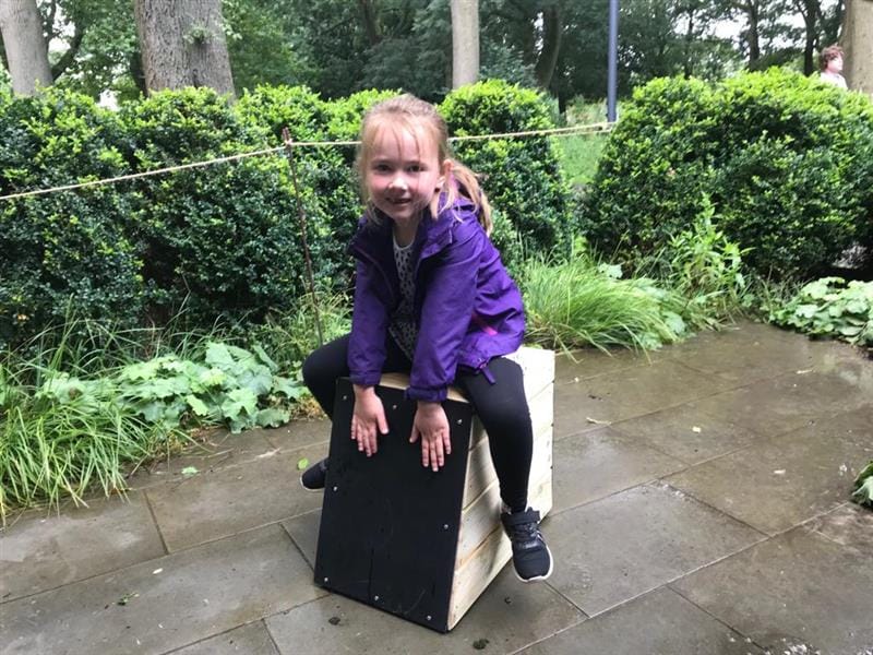 A early years girls is sat on the drum seat 