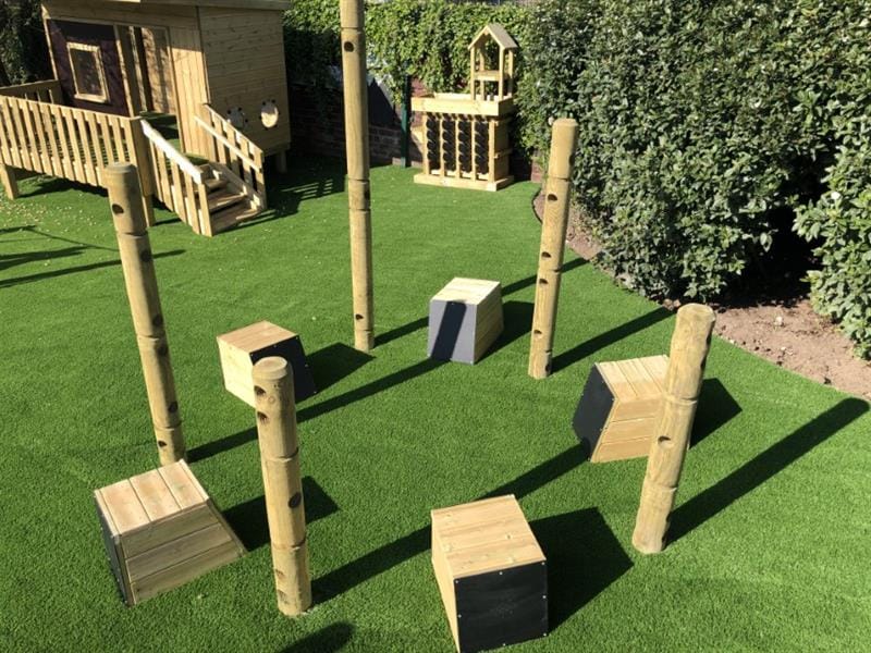 5 drum seats are placed in a circle with wooden poles in-between each drum. These poles can be used to create a den to make the music area more secluded.