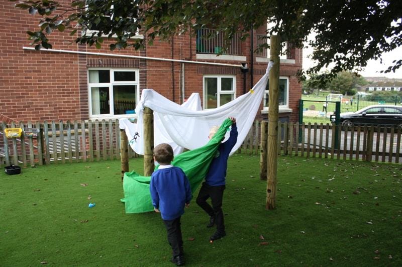 children put the white sheet through the holes in the den posts
