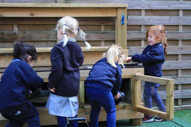 Children playing with a playground mud kitchen 