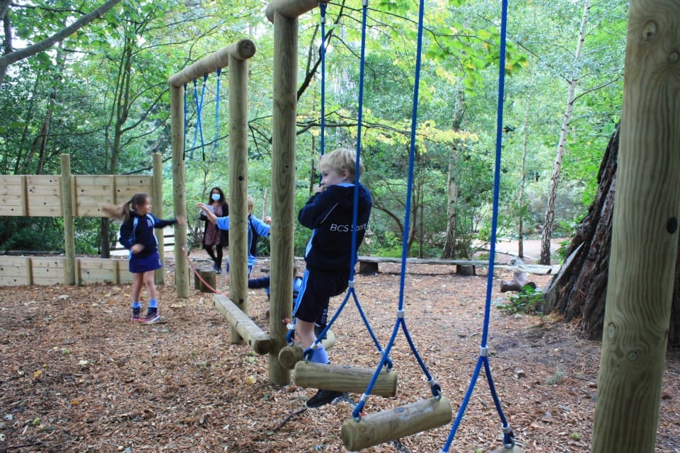 A picture of three children climbing through a trim trail that Pentagon Play installed