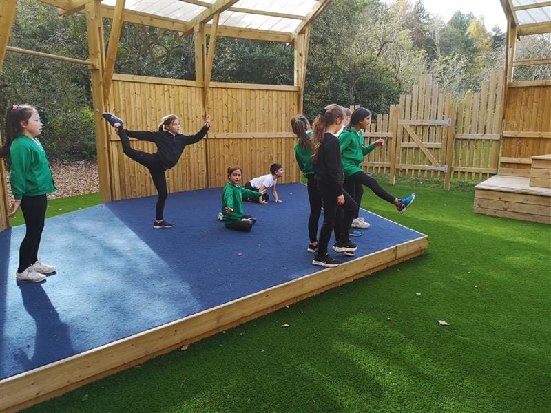 children stand on the stage and do yoga