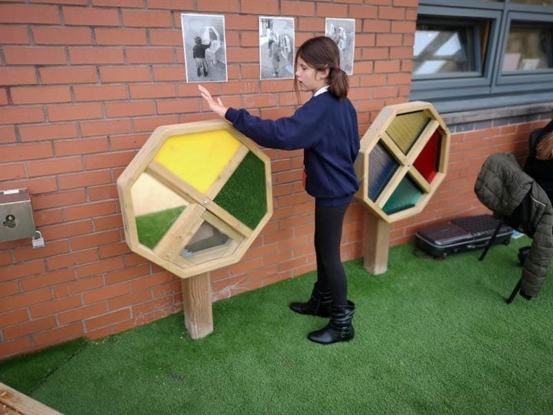 A young girl playing with the sensory spinner in her playground