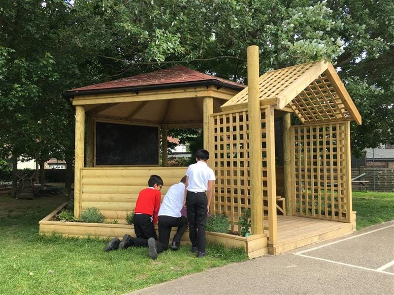 children gardening around the outside of the secret garden gazebo