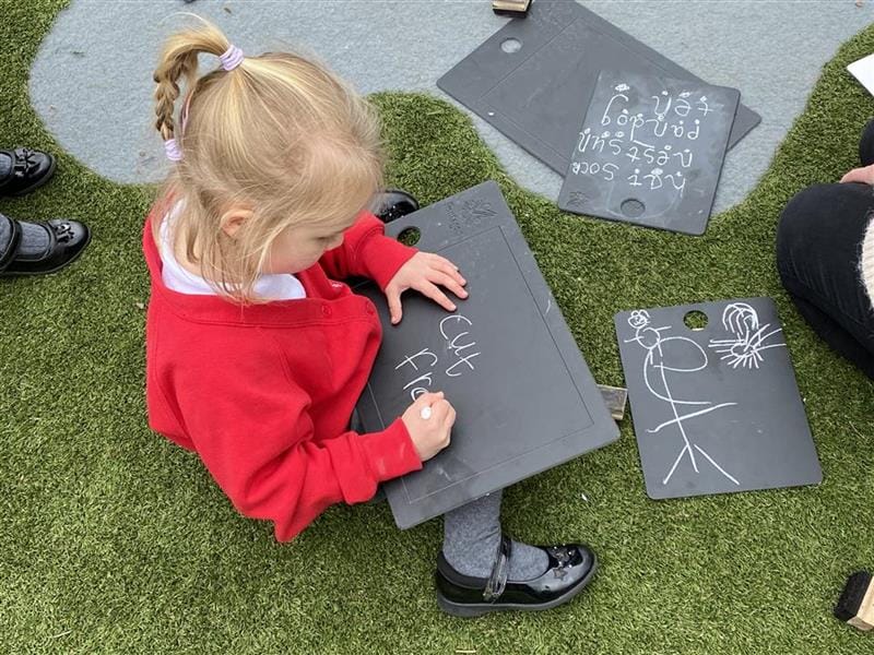 A girl drawing on our scribble boards.