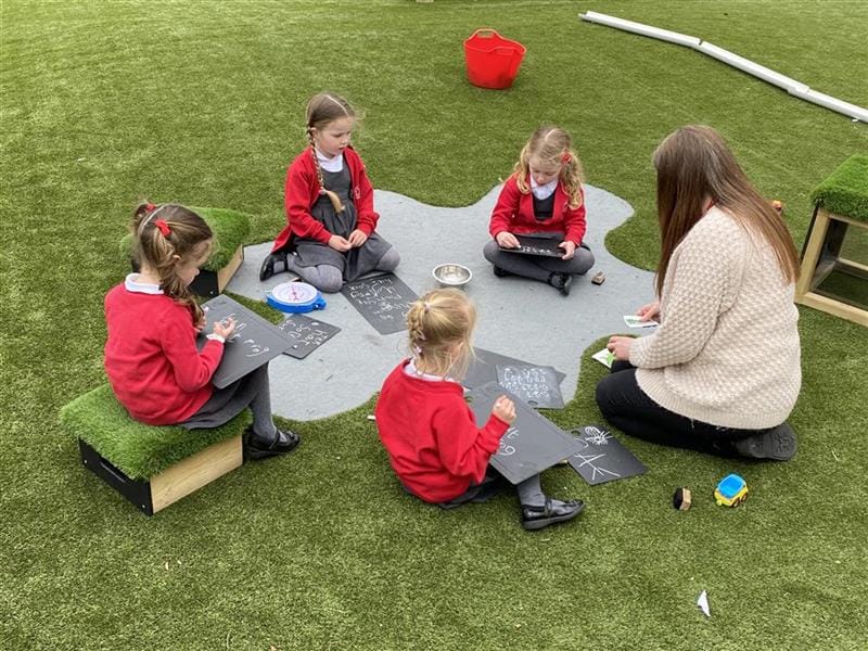 children sat using our scribble board