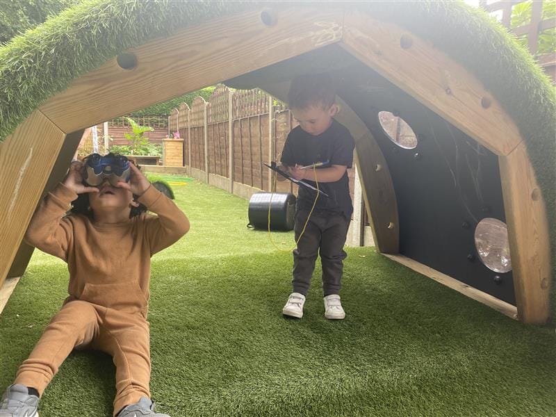 children sit in the little den