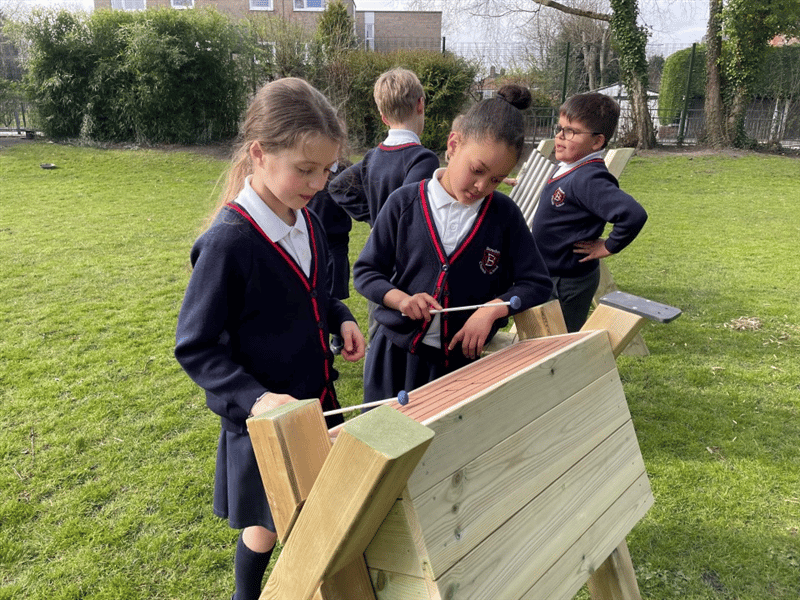 2 children using the tongue drum in their school field! 