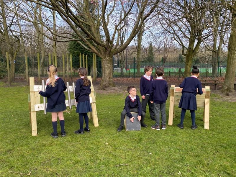 a group of children playing on their musical instruments on the school field 