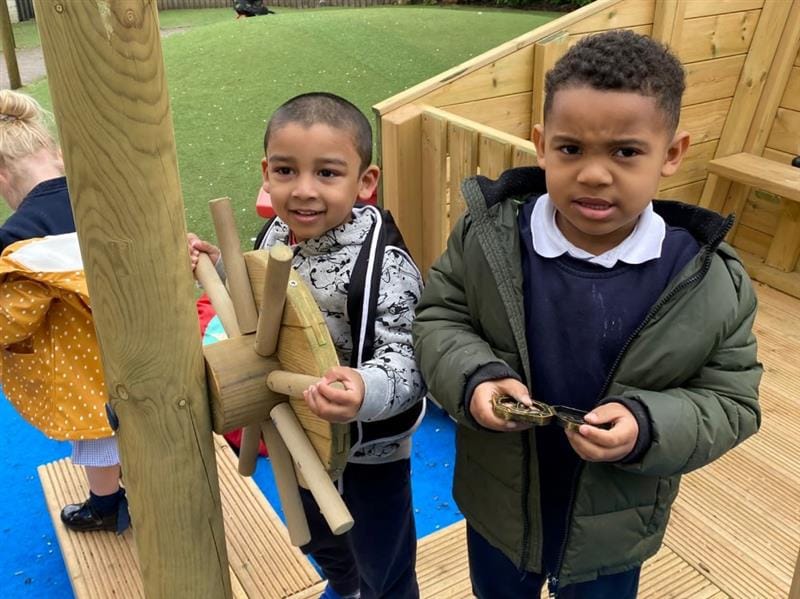 two little boys stand at the wheel of the ship and pretend to steer the boat