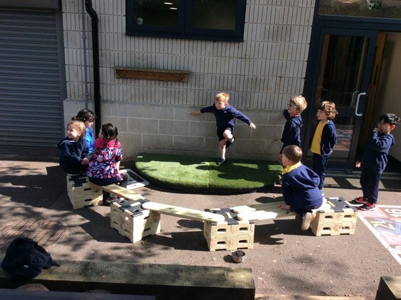 a child performs on the stage with his friends who stand and watch 