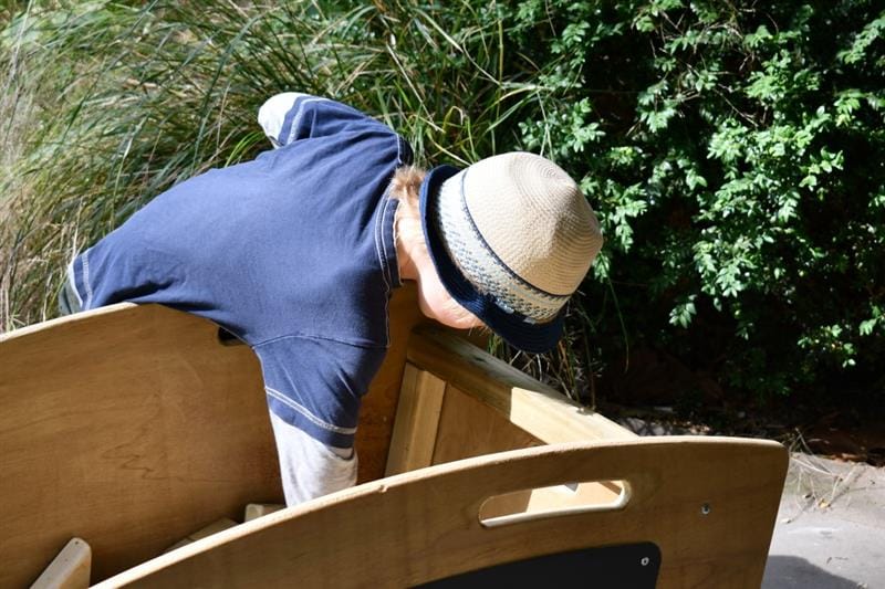 a child digs into the skip for wooden blocks to build with
