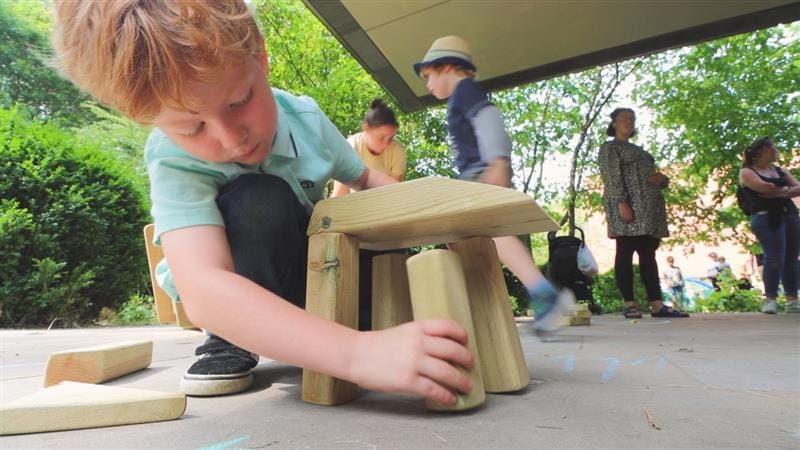 a child  builds with building blocks