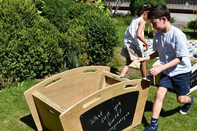 a child walks past the skip and looks inside to see what's available