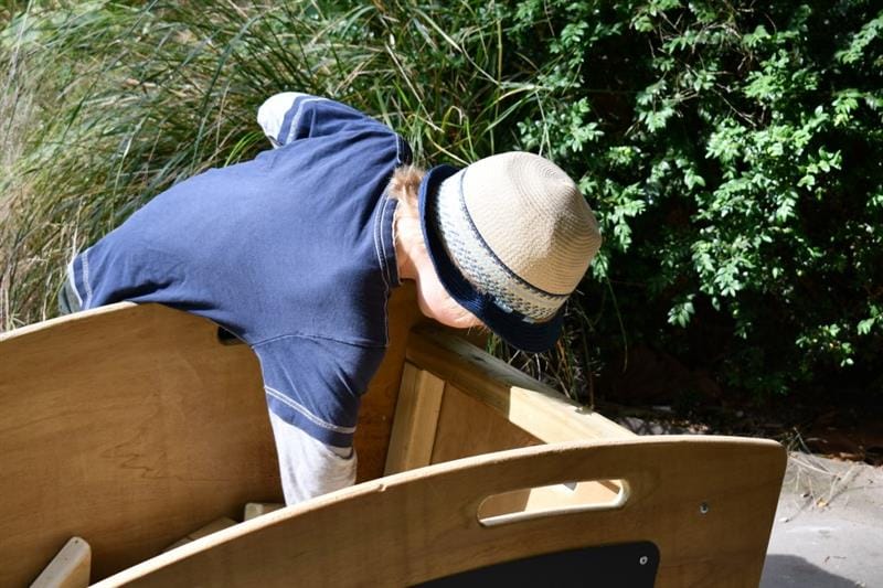 a child reaches into the skip for some more blocks