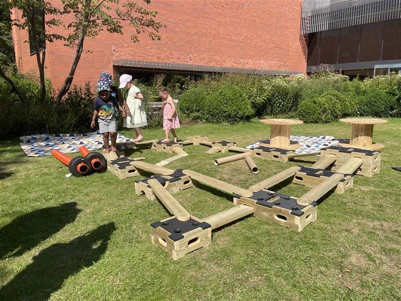 children cross the low-level play bulder trail