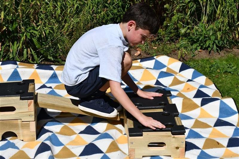 a child kneels and locks the pieces of play builder together securely
