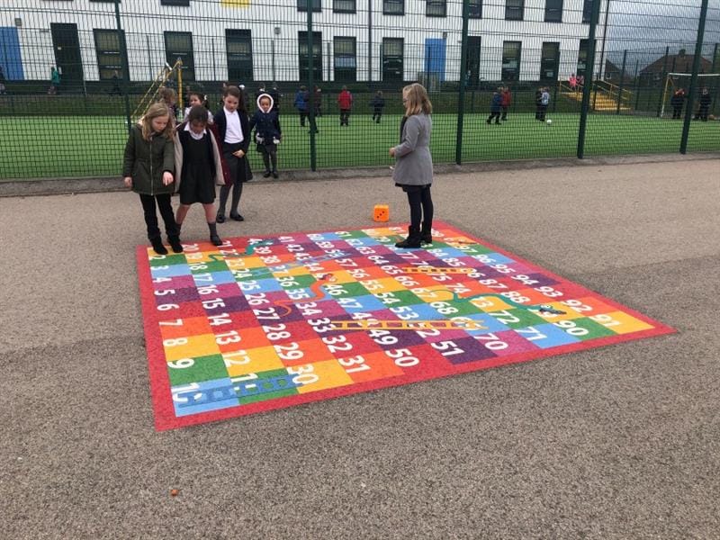 a bright rainbow snakes and ladders playground marking