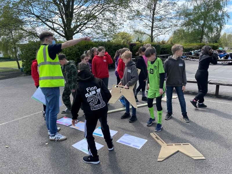 children gather around lifting the pieces of the leavers bench