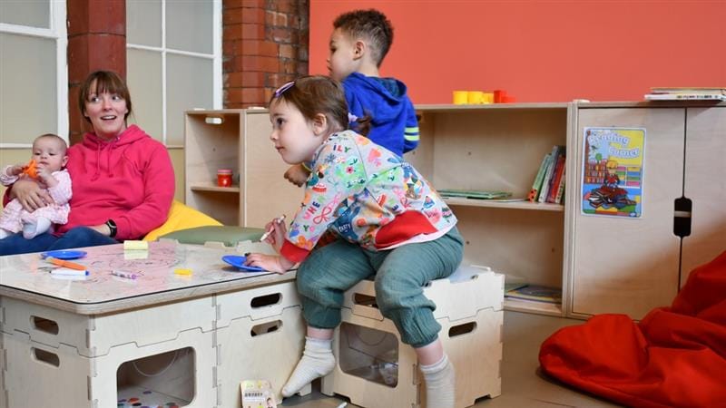 a low level space where children sit round the table and draw on the table top
