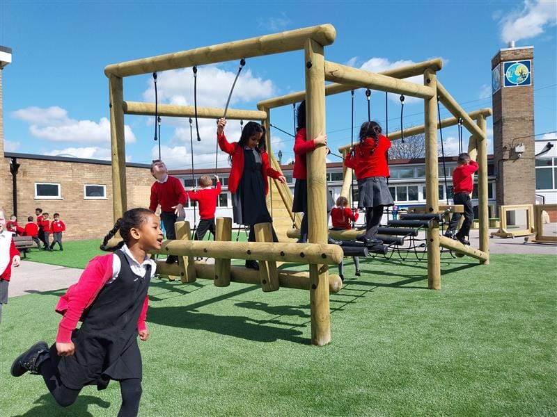 children climbing on their climbing frame in their playground setting
