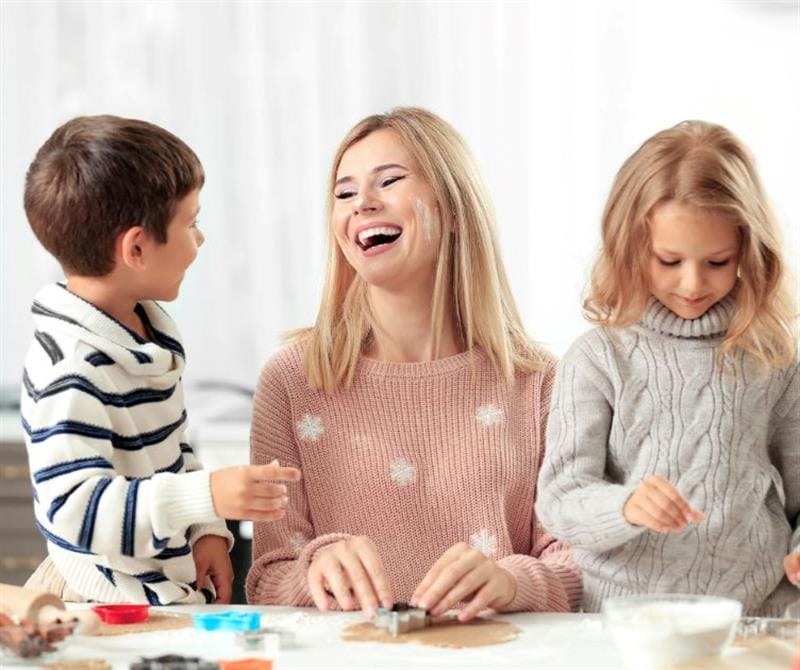 a woman sits with 2 children and talks