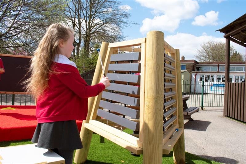 a little girl stands and plays music on the musical triad