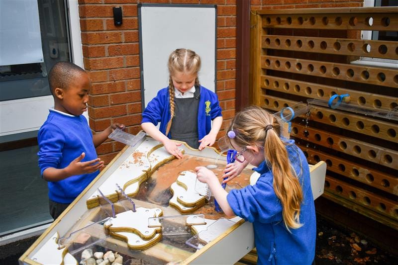 3 children playing with the new Pentagon Play Damming Station