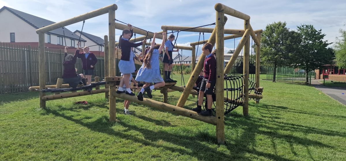 10 children all playing on the Whinlatter Climber, designed and installed by Pentagon Play