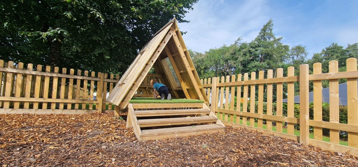 Child crawling inside of a floor den, created and installed by Pentagon Play