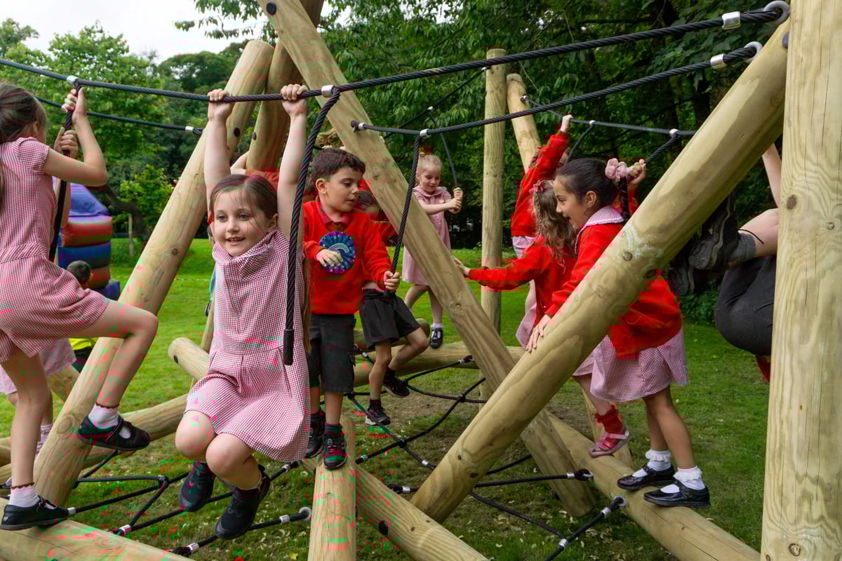 A large group of children are having fun on a Climber that was built and installed by Pentagon Play.