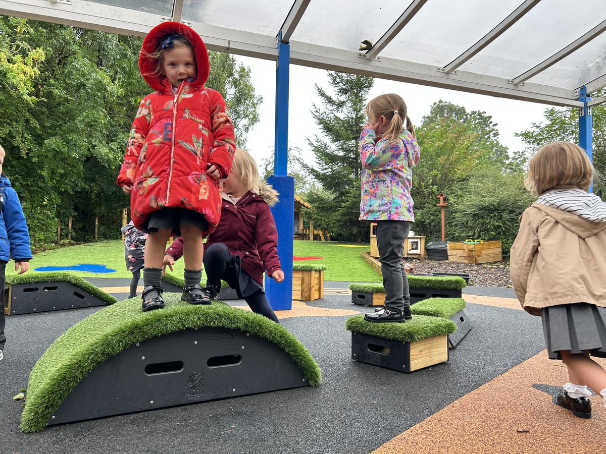 A group of children are playing on the Get Set Go blocks and are talking to each other.
