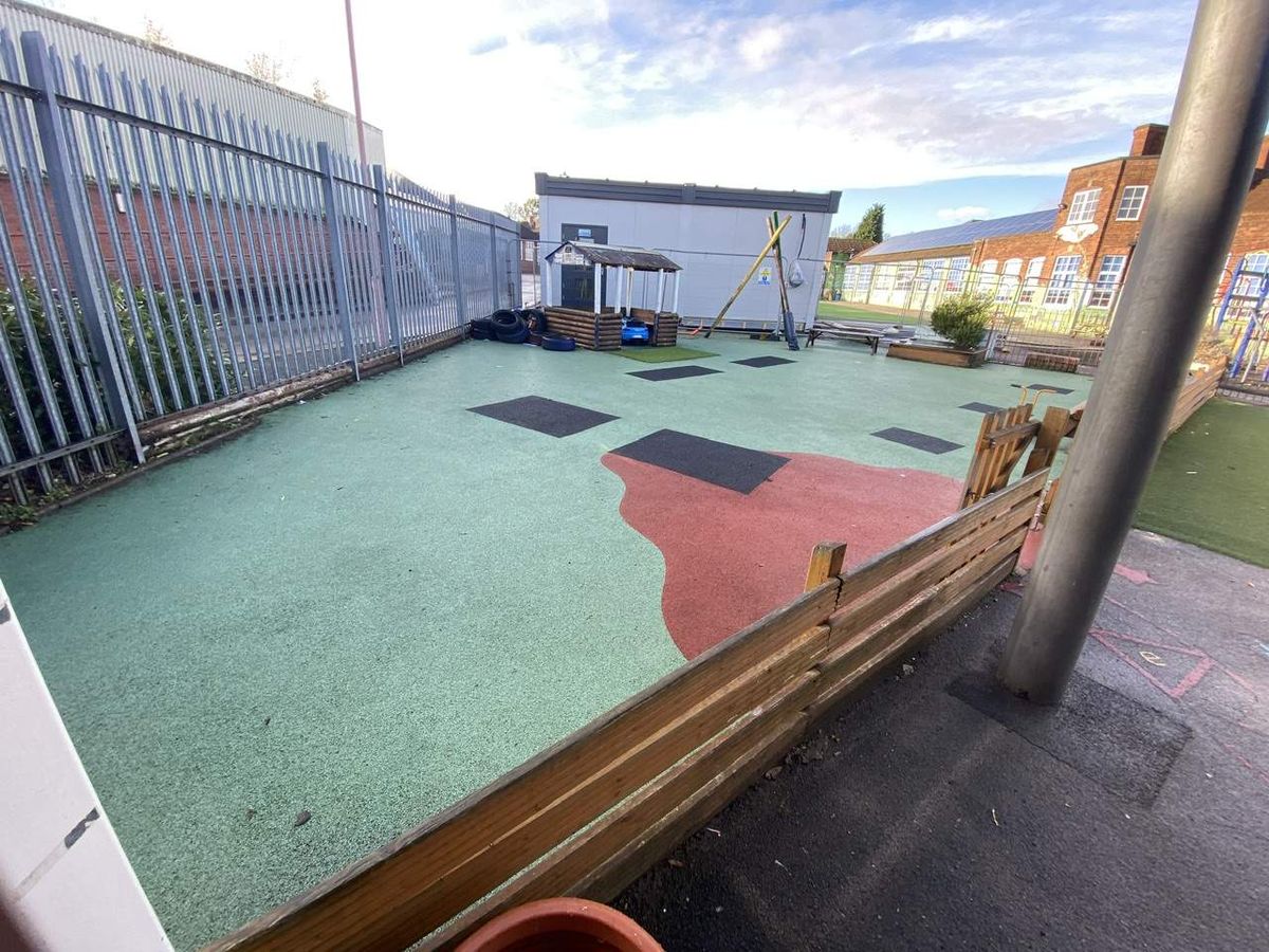 A playground with old and dirty wetpour surfacing.