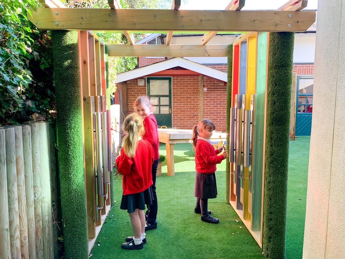 A group of children are engaging with the sensory equipment in the Sensory Arbour.