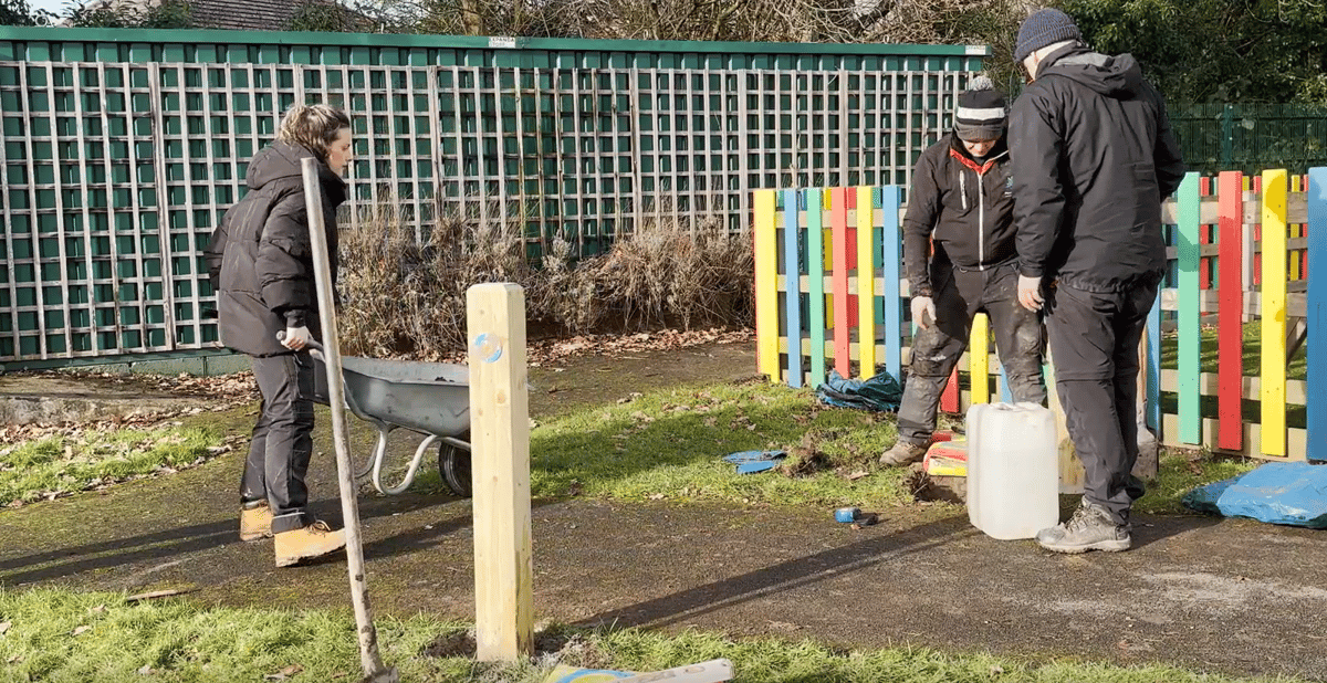 A group of three Pentagon Play employees are installing some play equipment.