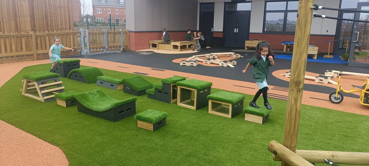 Two girls are playing on Get Set Go blocks and are jumping between them.